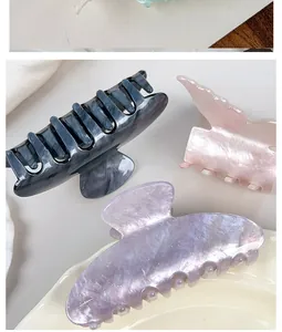 Gros plan de pinces à cheveux en acétate marbré, rose perle et violet pailleté