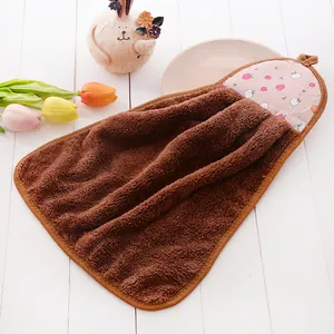 Close-up of brown coral fleece hanging hand towel with pink apple pattern detail