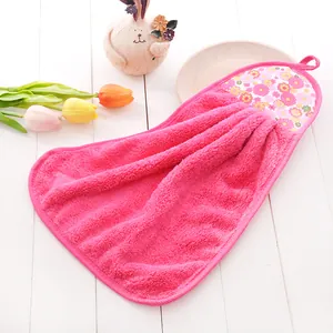 Close-up of coral fleece hand towel with floral patch and hanging loop for kitchen