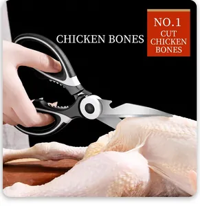 Close-up of stainless steel kitchen shears cutting through raw chicken bone on a dark background