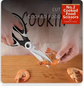 Close-up of multifunctional stainless steel kitchen scissors cutting cooked shrimp