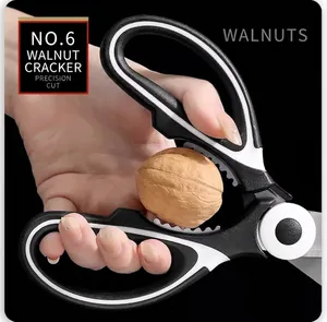 Detail showing multifunctional kitchen scissors crushing a walnut with serrated center notch