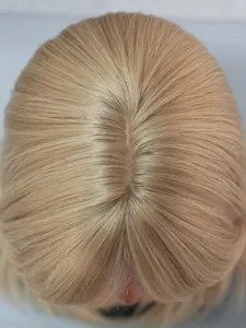 Detail of high-quality blonde synthetic wig showing realistic scalp and hair parting