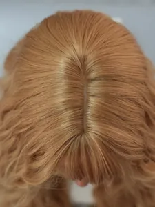 Macro shot of realistic synthetic scalp part on long wavy ginger blonde wig