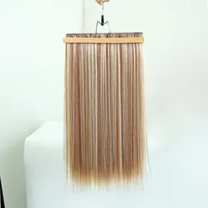 Détail d'extensions de cheveux synthétiques raides blondes à clip sur un cintre.