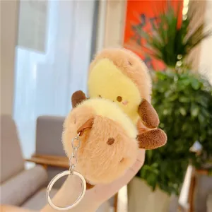 Cute plush potato keychain charms with silver metal rings held in hand, soft fluffy texture