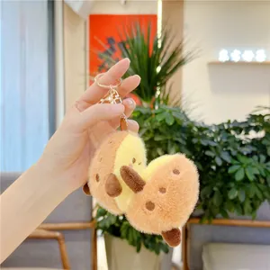 Macro detail of plush avocado keychain featuring soft faux fur and premium gold clasp