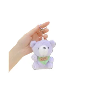 Purple plush teddy bear keychain with green polka dot scarf and silver metal clasp
