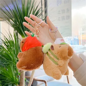 Close-up of cute capybara plush keychain wearing a baseball cap and backpack charms