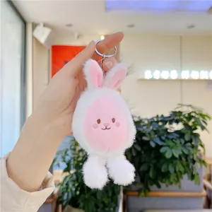 Detail of a plush bunny keychain with pink ears and a silver metal ring held in hand