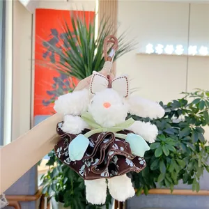 Détail d'un pendentif lapin en peluche blanche en robe à fleurs et fausse fourrure