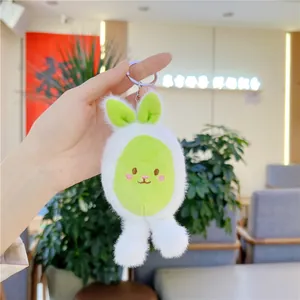 Close-up of a white plush bunny keychain with green accents and silver metal ring