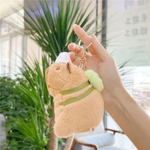Plush capybara keychain with green backpack and baseball cap for bag decoration