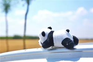 Close-up of a soft plush panda toy in a lying position against a natural scenic background