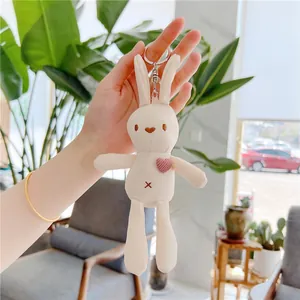 Detailed macro view of cream plush rabbit keychain with waffle texture and heart embroidery