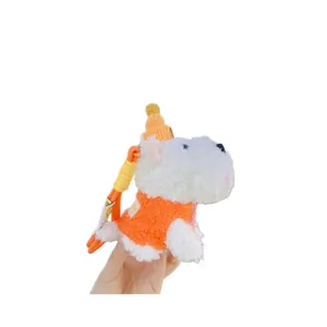 Cute white plush Westie dog keychain with orange sweater and yellow hat on hand