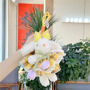 Détail d'un porte-clé lapin en peluche blanche en robe à carreaux et tulipes