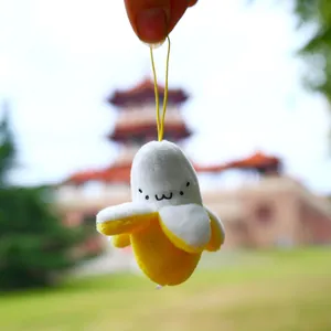 Close-up of a cute peeled banana plush pendant with a smiling face and yellow strap