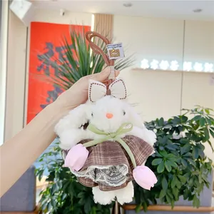 Détail de la peluche lapin blanc aux oreilles tombantes avec robe en dentelle et tulipe