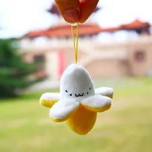 Detailed close-up of a plush peeled banana pendant with a cute smiling face and yellow cord