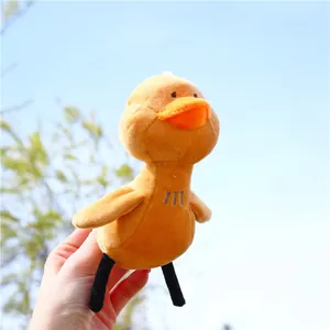Gros plan d'un petit porte-clés canard en peluche jaune sur fond de ciel bleu lumineux