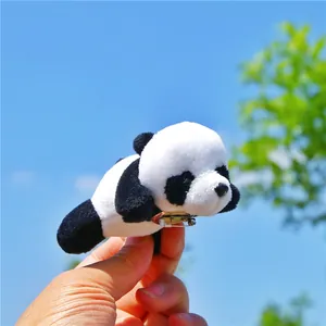 Cute plush panda brooch with metal pin shown against a blue sky for clothing or bags