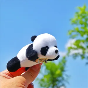 Close-up of a cute 3D plush panda brooch with metal pin against a sunny sky