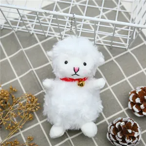 Close-up of cute white plush lamb keychain with red ribbon and golden bell detail