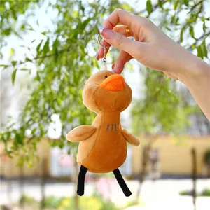 Gros plan d'un porte-clés canard en peluche jaune avec fermoir métallique tenu en main