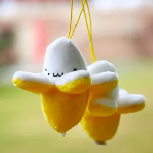 Macro view of cute peelable banana plush charms with expressive faces and soft fabric