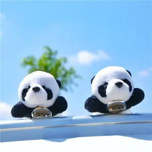 Cute plush panda brooches and charms set against a natural blue sky background