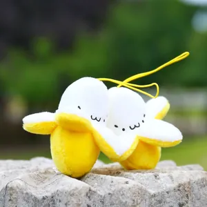 Close-up of cute plush banana keychains with embroidered smiling faces on a stone base