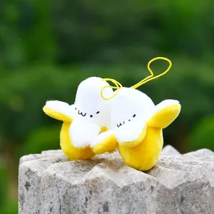 Detail of plush banana pendants with cute facial embroidery and yellow lanyards on stone