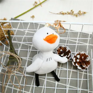 Cute white plush duck keychain with orange beak and gold metal clasp hanging on white mesh