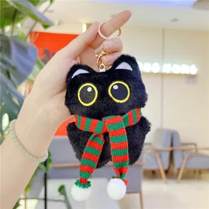 Detail view of cute black plush cat keychain with striped scarf and golden lobster clasp