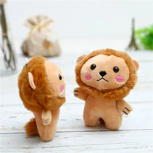 Close-up of soft lion plush charm with brown mane and embroidery on wooden desk
