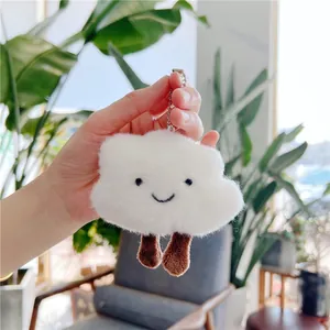 Detail of cute white cloud plush keychain with soft fur and tiny brown legs