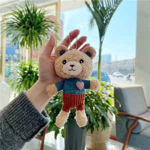 Cute teddy bear plush keychain wearing blue heart sweater and brown corduroy pants