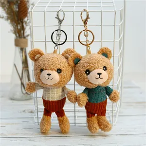 Detail of two teddy bear plush charms with plaid sweaters on a white wire basket