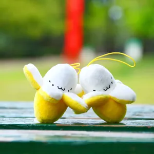 Macro detail of plush banana pendants with cute facial embroidery and yellow elastic straps