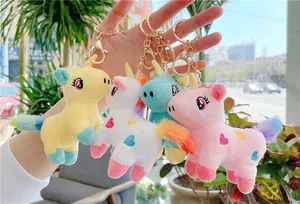 Handheld set of four plush unicorn keychains with rainbow manes and heart embroidery
