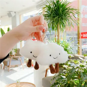 Close-up of cute plush white cloud keychain with smiling face and soft fur texture