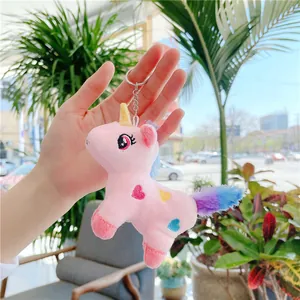 Pink plush unicorn keychain with gold horn and heart embroidery on a silver metal ring