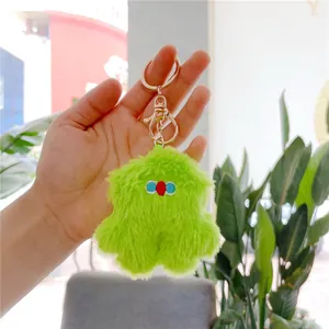 Neon green plush monster keychain with embroidered eyes and golden metal clip