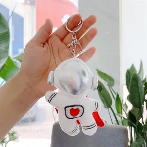 Detail of plush astronaut keychain with silver mask, red heart embroidery and cape