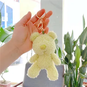 Close-up of a soft lime green teddy bear plush keychain with a gold metal ring and clasp
