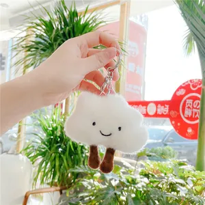 Close-up of white plush cloud keychain with cute smile embroidery and metal ring