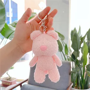 Detailed close-up of a pink plush teddy bear keychain with soft faux shearling texture