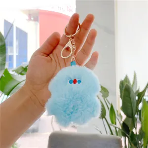Detailed close-up of a light blue plush keychain with a gold metal lobster clasp being held