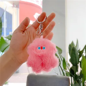 Detailed close-up of a pink plush monster charm with a silver metal keychain clasp